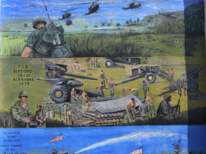 A large-scale community memorial mural, painted panel by panel on an exterior wall.